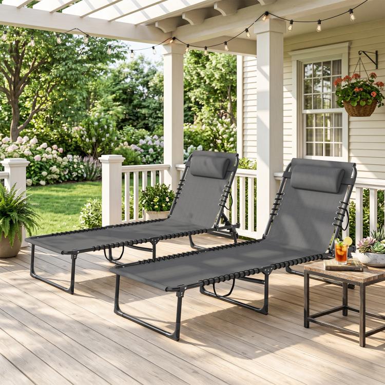 Gray folding chaise lounge chairs with padded headrests on outdoor porch