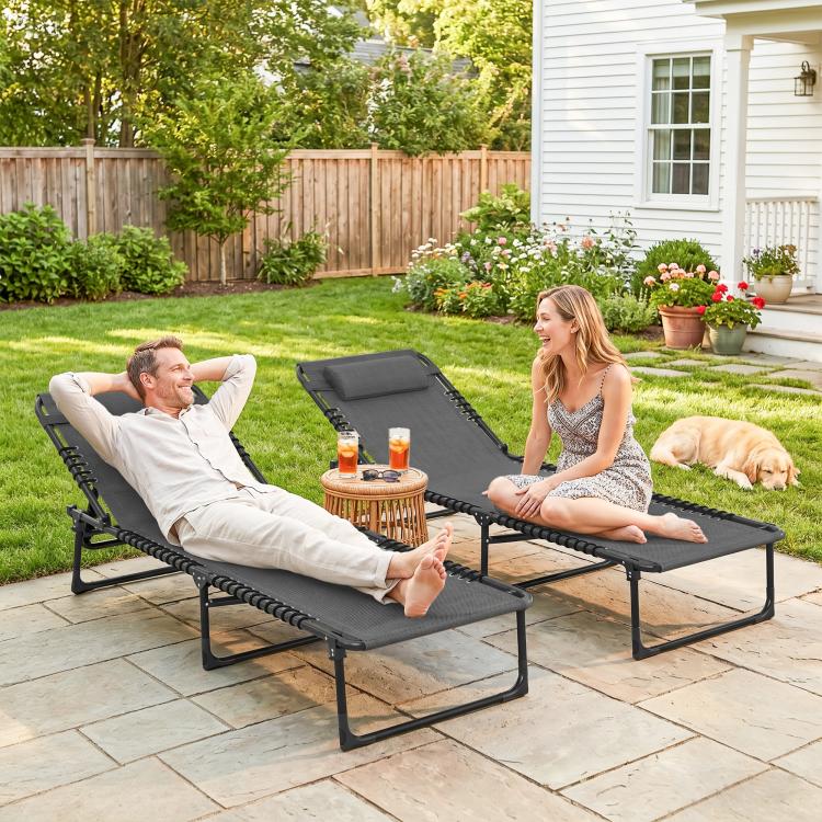 Gray folding chaise lounge chairs for two people with adjustable backs on patio