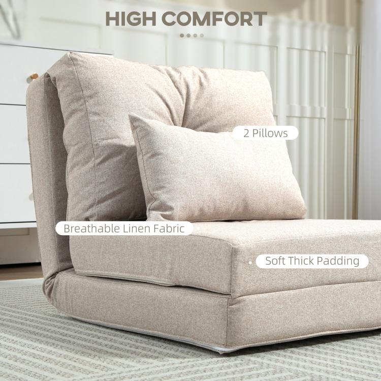 Beige upholstered floor chair with two decorative pillows and thick padded seat