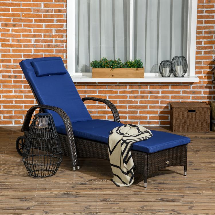 Outdoor reclining chaise lounge with blue cushion, headrest pillow, and wicker frame