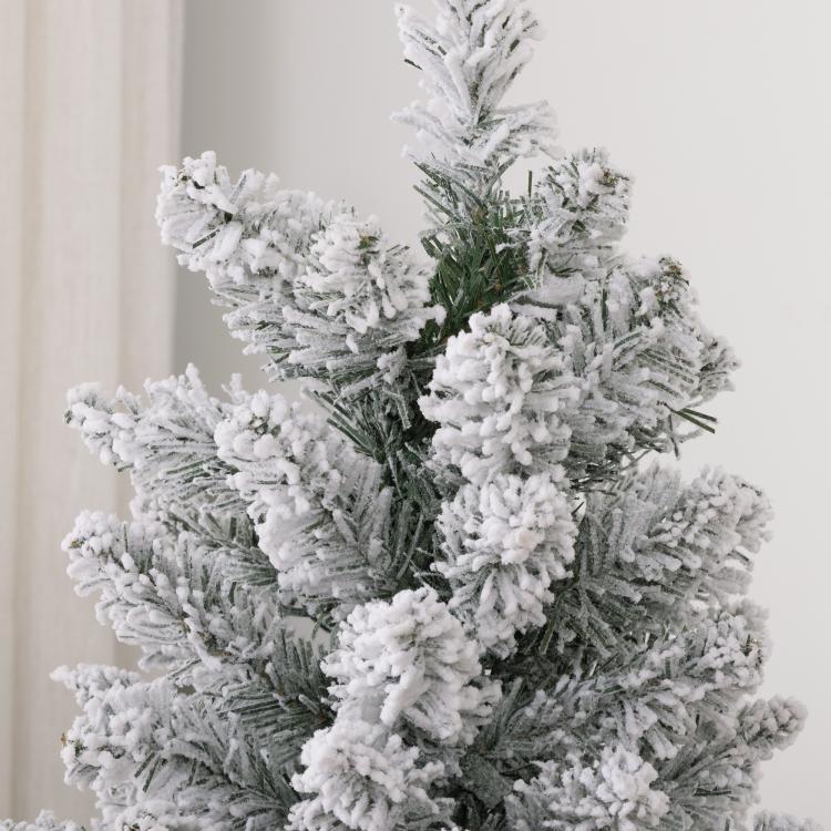Snow flocked artificial Christmas tree with dense pencil branches, green and white needles