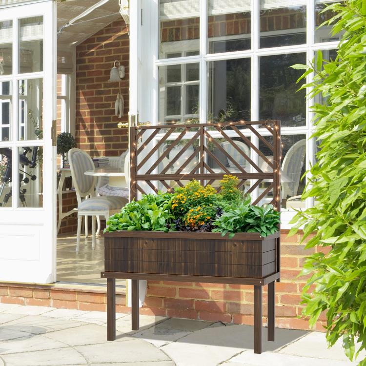 Dark wood raised planter with trellis on a patio near windows and greenery
