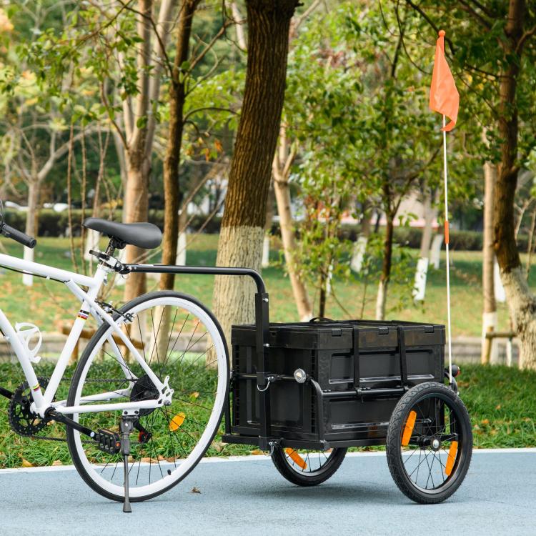 Bike cargo trailer with black wagon box, orange safety flag, attached to bicycle