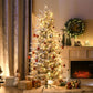 Lit artificial Christmas tree with snow-dusted branches and red ornament accents