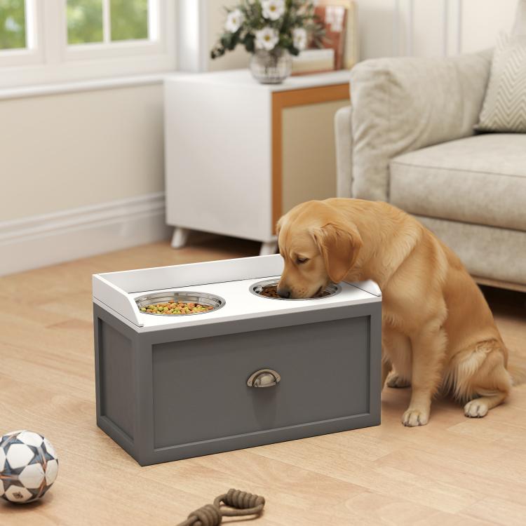 Gray elevated pet feeding station with two bowls and storage drawer, with dog eating