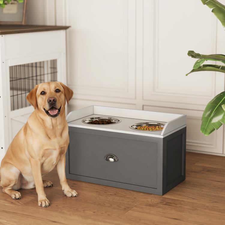 Gray pet feeding station with two raised bowls and front storage drawer, with seated dog