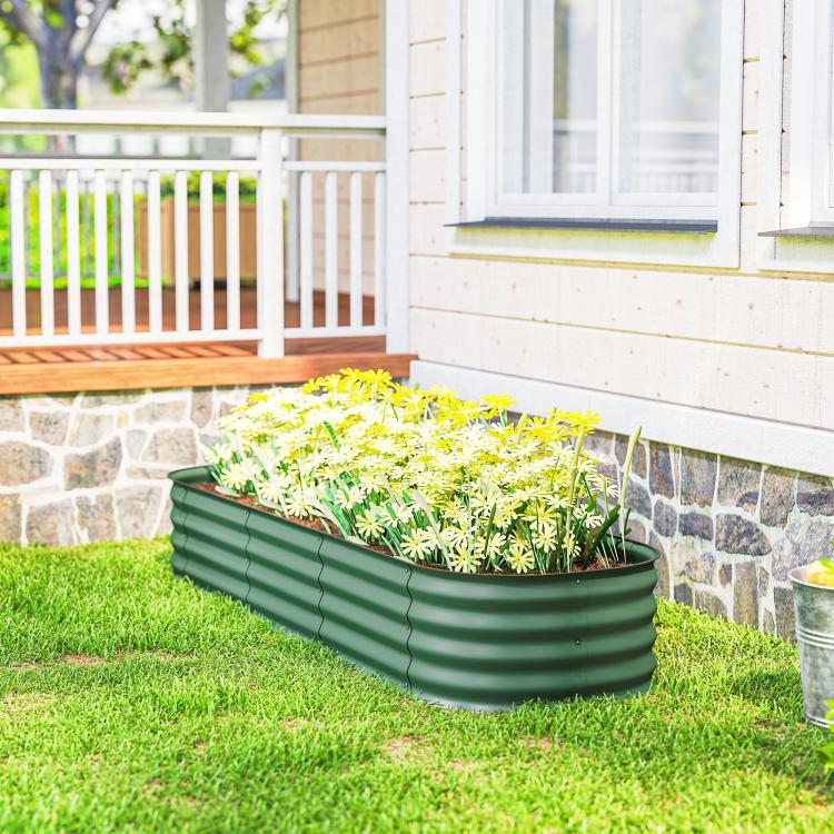 Green galvanized raised garden bed planter box with safety edging, filled with seedlings