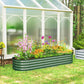 Green metal raised garden bed planter with safety edging, outdoors with flower plants