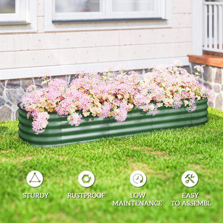 Green metal raised garden bed planter with pink flowers, outdoor yard setting