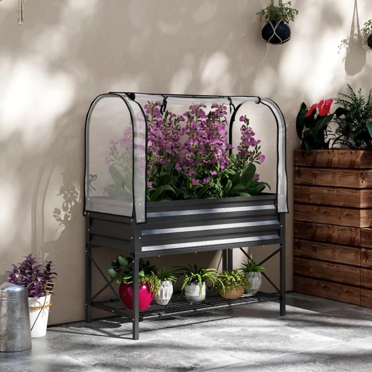 Black raised garden bed planter with clear mesh cover and purple flowers