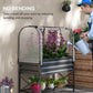 Black raised garden bed planter with clear mesh cover while watering with a can