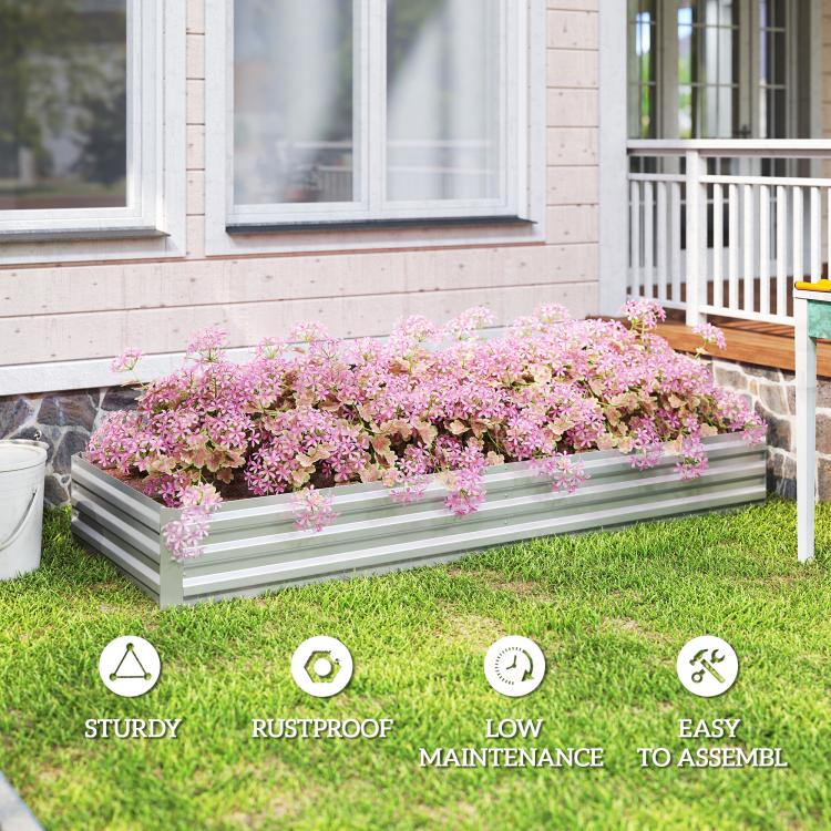 Silver galvanized raised garden bed planter with pink flowers on a lawn