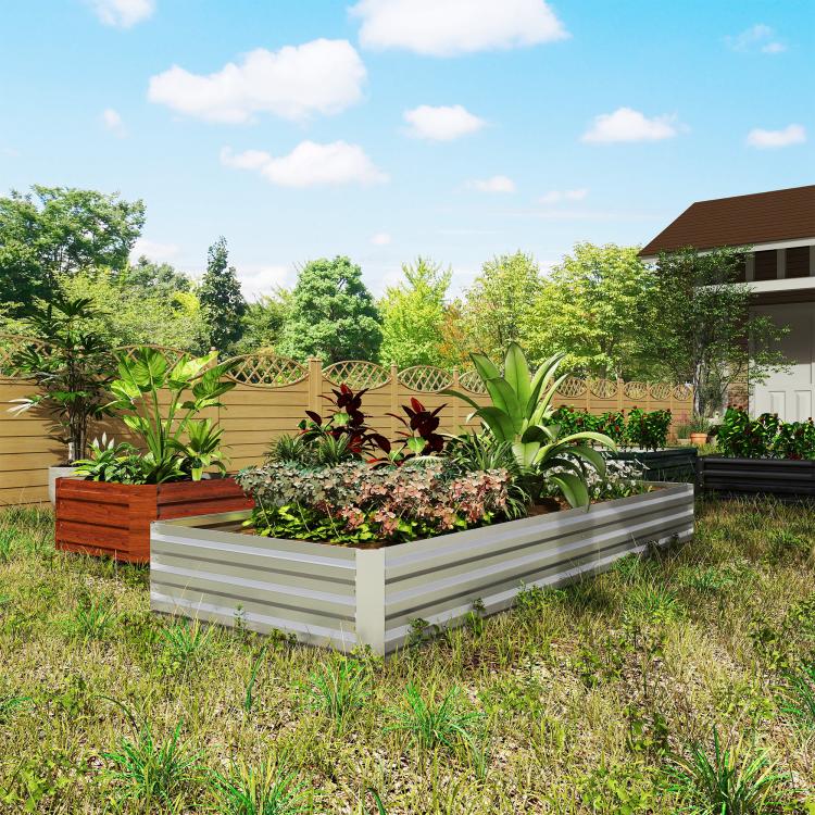 Silver galvanized raised garden bed planter with mixed plants in outdoor yard