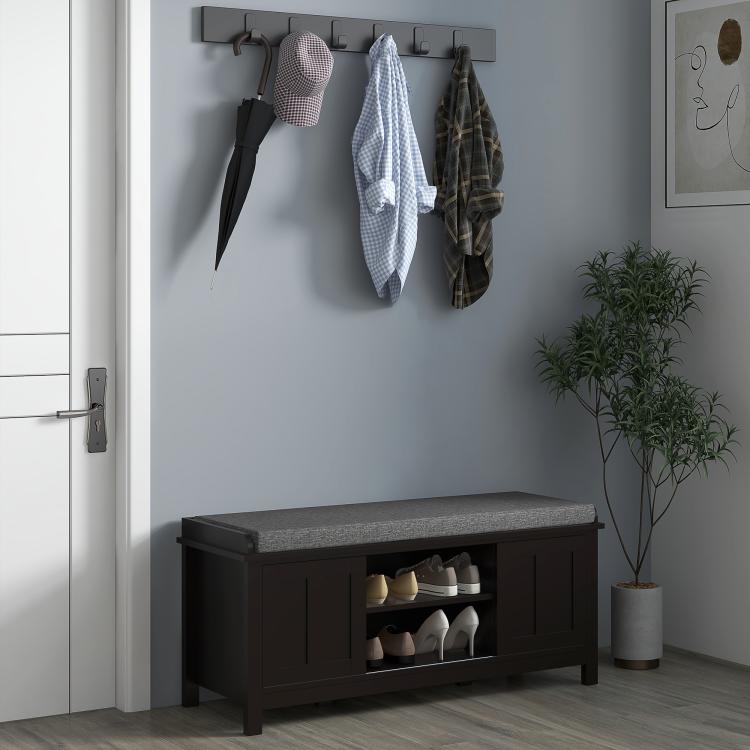 Black shoe storage bench with gray cushion and open shelf with shoes