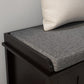 Close-up of gray linen cushion on black shoe storage bench with padded seat edge