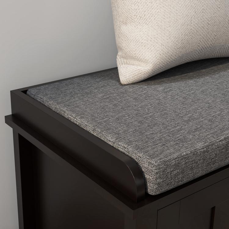 Close-up of gray linen cushion on black shoe storage bench with padded seat edge