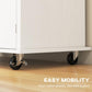 White rolling kitchen island cart on four caster wheels with two wheel brakes