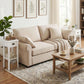 White 2-tier side table with drawer and open shelf beside a beige sofa.