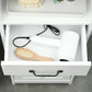 White pull-out drawer with black handle, holding hair brush and toiletries