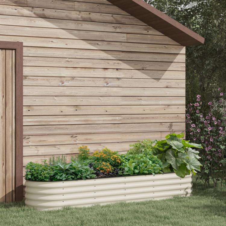 Cream metal raised planter bed with ridged sides, filled with leafy herbs beside a wall