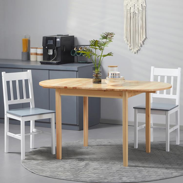 Natural wood drop-leaf dining table with two white chairs in a modern kitchen