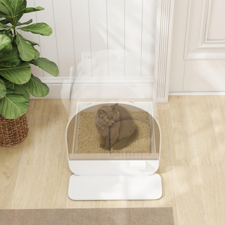 Closed white cat litter box with lid open, showing beige litter and standing cat