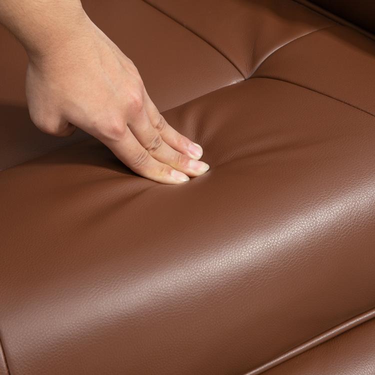 Brown leather-look recliner seat close-up with hand smoothing the cushion