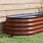 Brown metal raised garden bed with rolled safety edge and corrugated walls, outdoor
