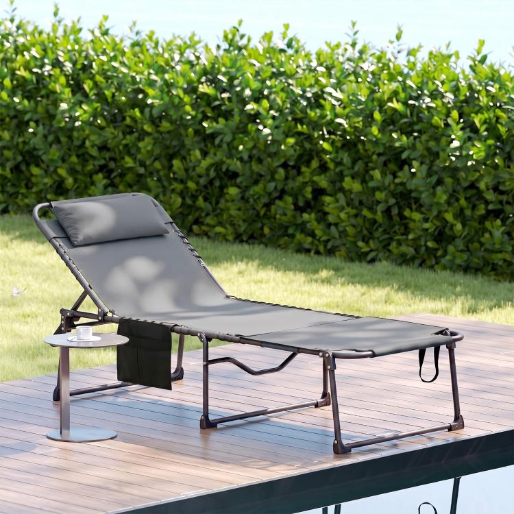 Gray folding tanning lounge chair with reclining back, headrest, and side pocket