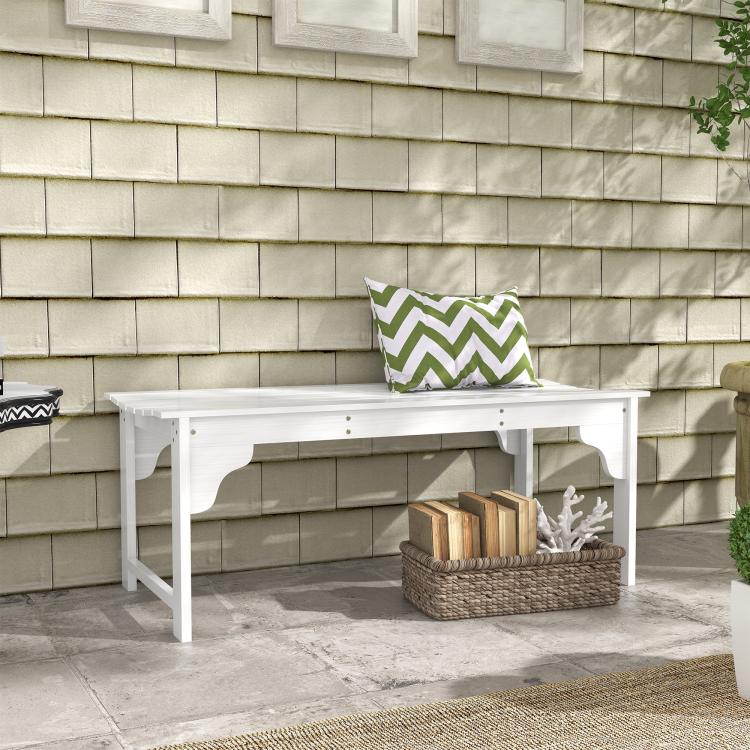 White slatted wooden garden bench with curved apron and pillow on the seat
