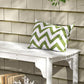 White slatted wooden garden bench with curved apron and green-and-white zigzag cushion
