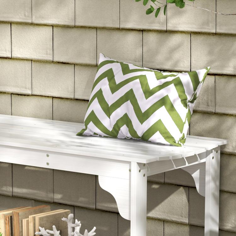 White slatted wooden garden bench with curved apron and green-and-white zigzag cushion