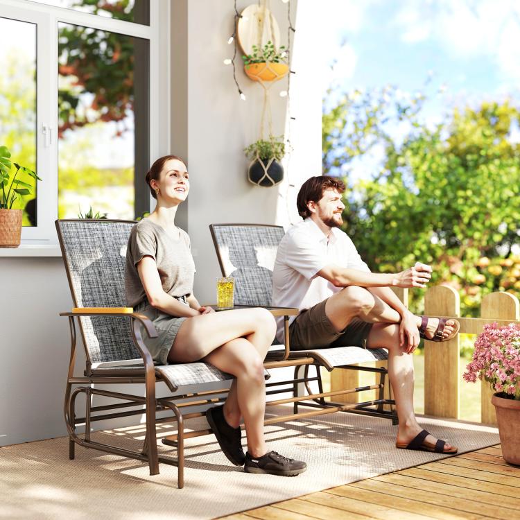 Outdoor gray glider loveseat bench with curved armrests and middle table