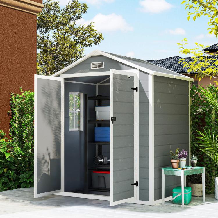 Gray outdoor storage shed with doors open, showing interior shelving and items