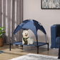 Dark blue elevated dog cot with UV canopy, featuring a small dog resting on the bed