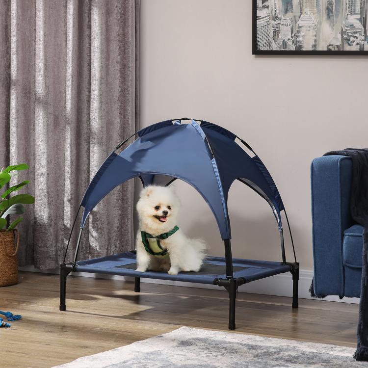 Dark blue elevated dog cot with UV canopy, featuring a small dog resting on the bed