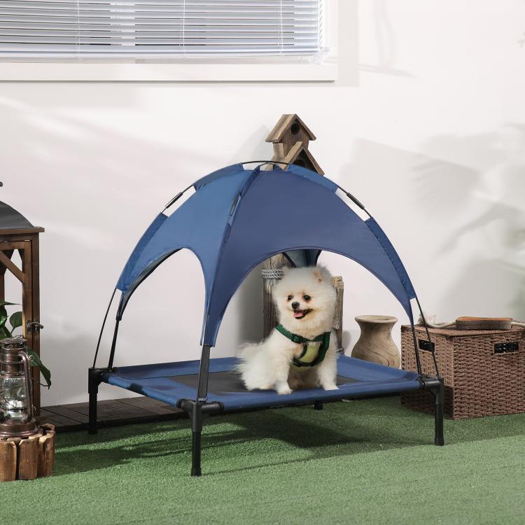 Dark blue elevated dog cot with UV canopy shade and black frame on indoor floor