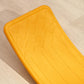 Orange balance board with raised textured pattern on the curved surface