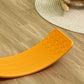 Orange balance board on wood floor with textured grip surface visible