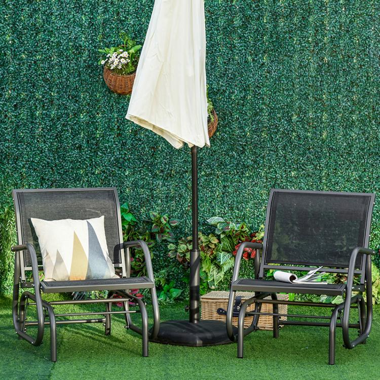 Two outdoor rocking glider chairs with gray mesh seats and black frames on green lawn