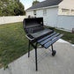 Charcoal barbecue grill with open lid, wire cooking grate, side shelves, and wheels