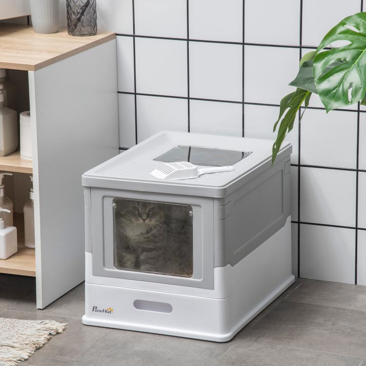 Gray and white enclosed cat litter box with front window opening in a corner setup