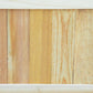 Close-up of light natural wood slat side panels on a raised garden bed planter