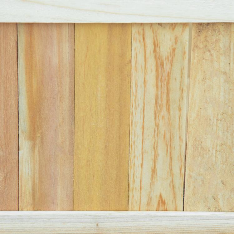 Close-up of light natural wood slat side panels on a raised garden bed planter