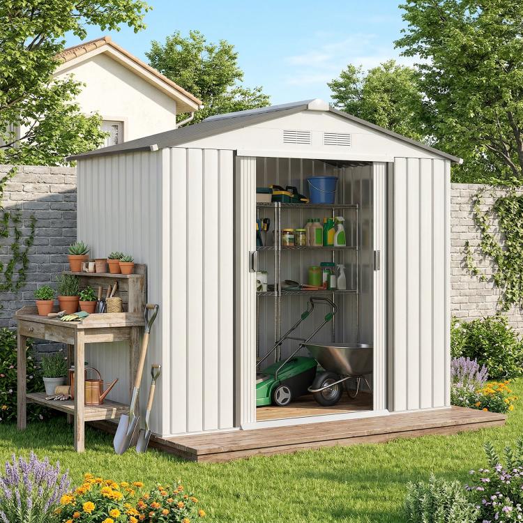 White outdoor storage shed with sliding doors open, gardening supplies on shelves inside