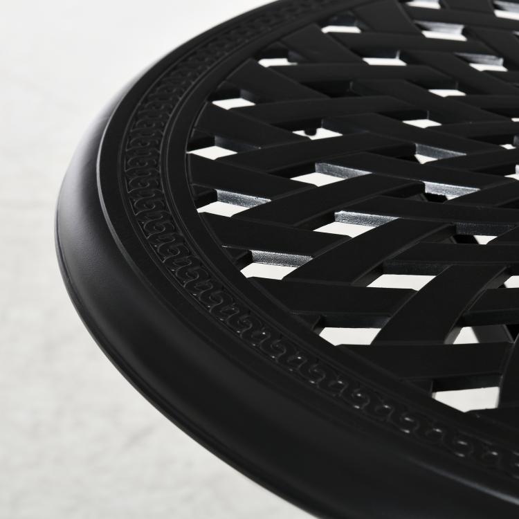 Close-up of black round lattice tabletop edge with decorative rim pattern