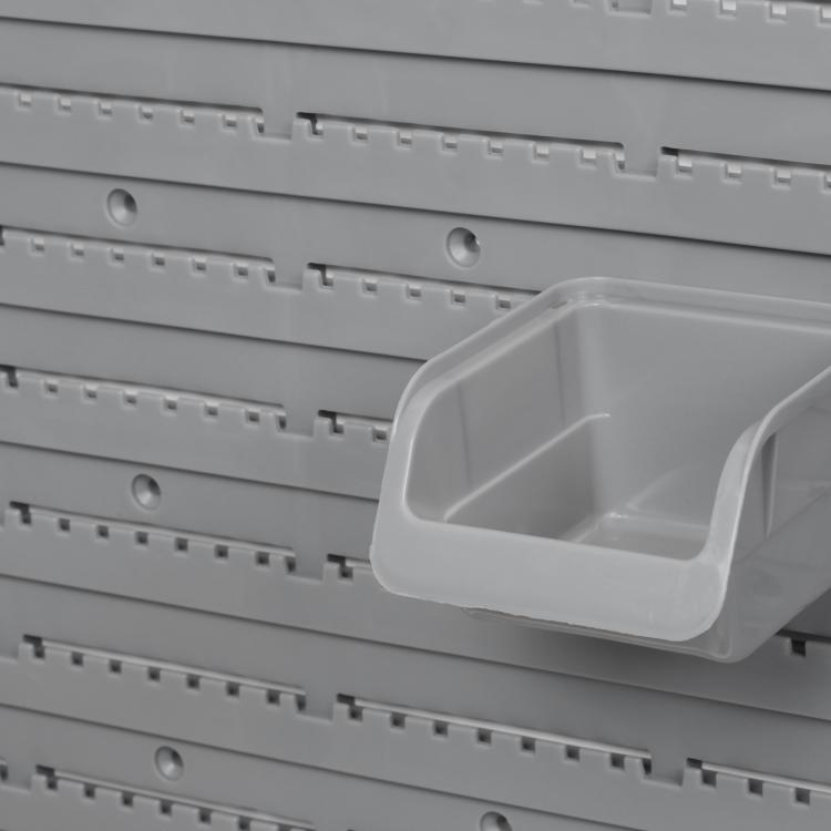 Close-up of gray pegboard holes with a mounted square storage bin