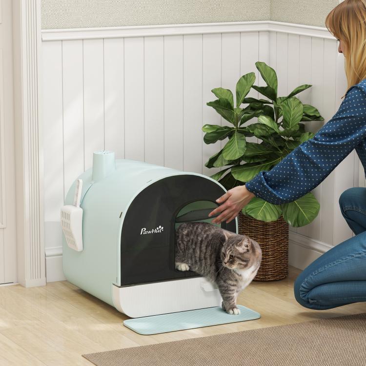 Enclosed cat litter box with open entry showing gray cat inside on a blue mat