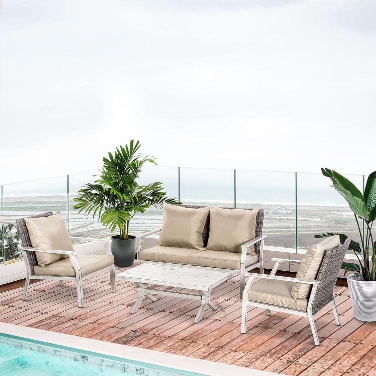 Outdoor conversation set with beige cushions, woven wicker seats, and white coffee table