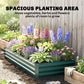 Green raised garden bed packed with colorful flowers in a neat row